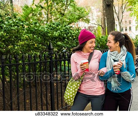 Twins walking with coffee in park View Large Photo Image Stock Image - Twins walking with coffee in park. Fotosearch