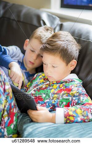 Stock Photo - Two boys using a digital tablet. Fotosearch