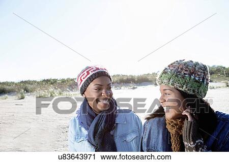 Two female friends relaxing at beach in winter View Large Photo Image Stock Image - Two female friends relaxing at beach in winter. Fotosearch