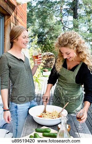 Two friends preparing lunch al fresco View Large Photo Image Stock Image - Two friends preparing lunch al fresco. Fotosearch