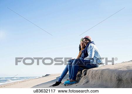 "Two friends sitting on beach, looking at view" View Large Photo Image Stock Photo - "Two friends sitting on beach, looking at view". Fotosearch
