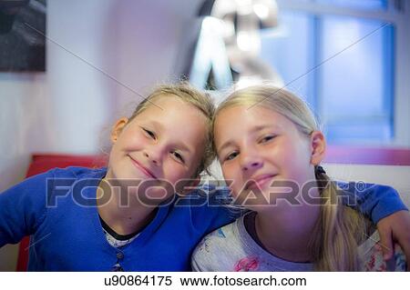 Stock Photography - Two girls smiling arms around each other. Fotosearch