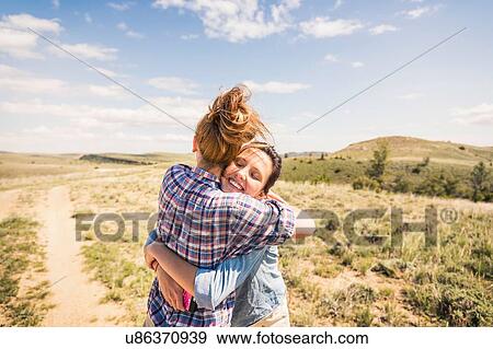 Two young women hugging each other on dirt track, Bridger, Montana, USA View Large Photo Image Stock Photo - Two young women hugging each other on dirt track, Bridger, Montana, USA. Fotosearch