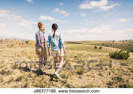 Two young women walking in hills, Bridger, Montana, USA View Large Photo Image Stock Photograph - Two young women walking in hills, Bridger, Montana, USA. Fotosearch