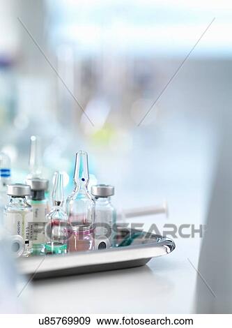 Stock Photo - Variety of drugs and syringe on tray. Fotosearch