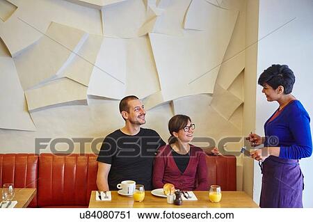 Waitress taking order in restaurant from mid adult couple View Large Photo Image Stock Image - Waitress taking order in restaurant from mid adult couple. Fotosearch