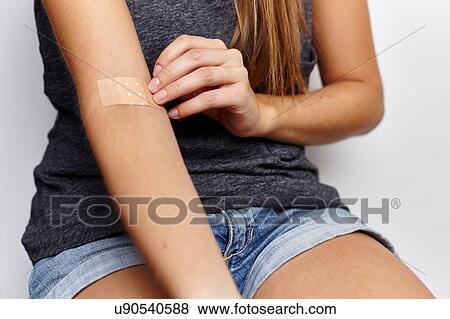 Woman applying plaster on right arm View Large Photo Image Stock Photo - Woman applying plaster on right arm. Fotosearch