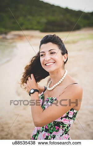 Stock Photo - Woman at the beach, hands in hair. Fotosearch