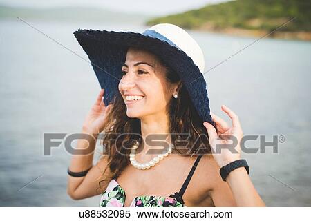 Woman by the sea, wearing hat View Large Photo Image Stock Photography - Woman by the sea, wearing hat. Fotosearch
