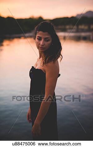 Stock Photograph - Woman by the sea, wearing long dress. Fotosearch