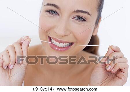 Stock Photo - Woman flossing teeth. Fotosearch