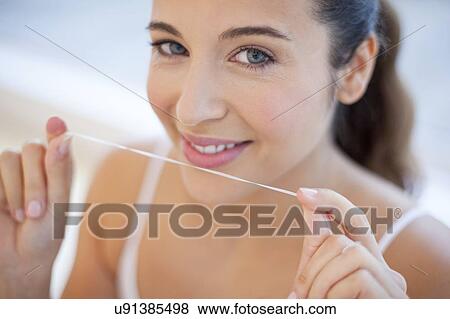 Stock Photo - Woman flossing teeth. Fotosearch