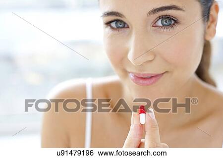Woman holding a capsule View Large Photo Image Stock Photograph - Woman holding a capsule. Fotosearch