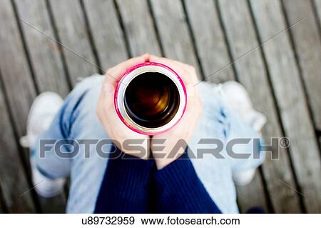Woman holding drinks flask, high angle view View Large Photo Image Stock Photo - Woman holding drinks flask, high angle view. Fotosearch