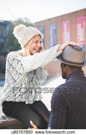 Woman laughing, resting hand on man's hat View Large Photo Image Stock Image - Woman laughing, resting hand on man's hat. Fotosearch