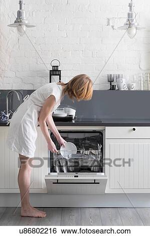 Woman loading dishes into dishwasher View Large Photo Image Stock Photograph - Woman loading dishes into dishwasher. Fotosearch