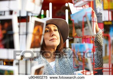 Woman looking at postcards in shop View Large Photo Image Stock Photography - Woman looking at postcards in shop. Fotosearch