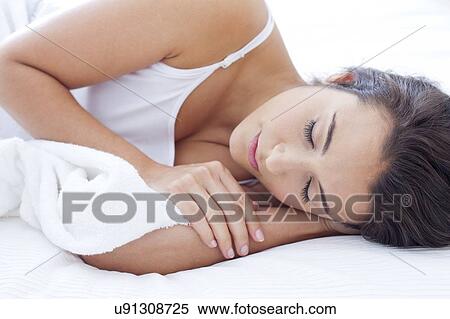 Stock Photography - Woman lying in bed asleep. Fotosearch