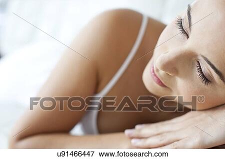 Stock Photo - Woman lying with head on hands. Fotosearch