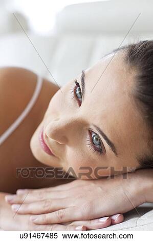 Stock Photography - Woman lying with head on hands. Fotosearch