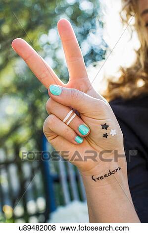 Woman making peace sign with hand View Large Photo Image Stock Photo - Woman making peace sign with hand. Fotosearch