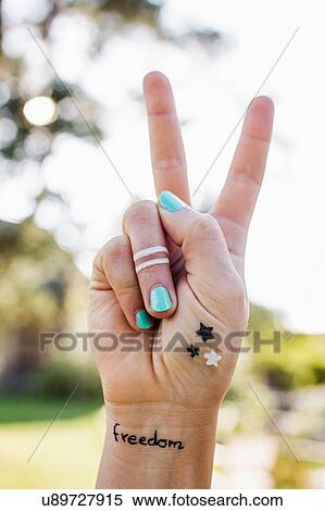 Stock Photography - Woman making peace sign with hand. Fotosearch