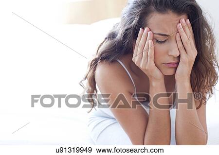 Stock Photo - Woman on bed in pain. Fotosearch