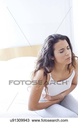 Woman on bed with cramps View Large Photo Image Stock Image - Woman on bed with cramps. Fotosearch