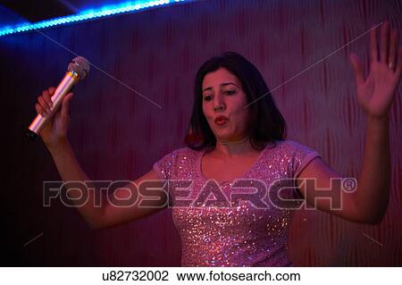 Woman singing karaoke View Large Photo Image Stock Image - Woman singing karaoke. Fotosearch