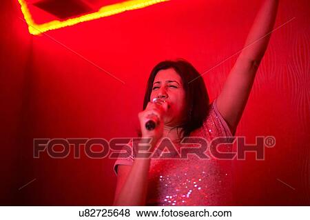 Woman singing karaoke View Large Photo Image Stock Photo - Woman singing karaoke. Fotosearch