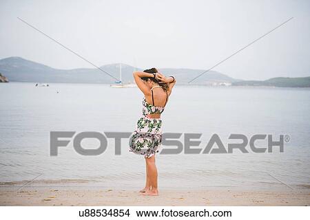 Picture - Woman standing at water's edge, Alghero, Sassari, Sardinia, Italy. Fotosearch