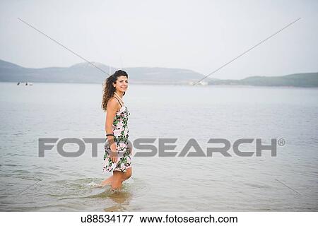 Stock Photo - Woman standing in sea, Alghero, Sassari, Sardinia, Italy. Fotosearch