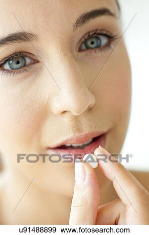 Stock Photo - Woman taking a tablet. Fotosearch
