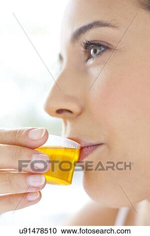 Stock Image - Woman taking medicine. Fotosearch