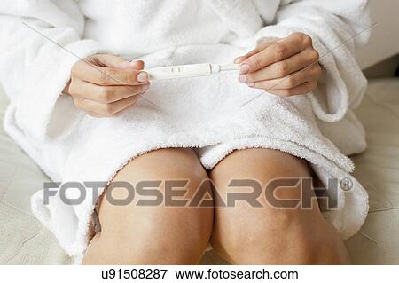 Stock Photo - Woman taking pregnancy test. Fotosearch