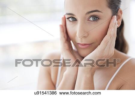 Stock Photograph - Woman touching her face. Fotosearch