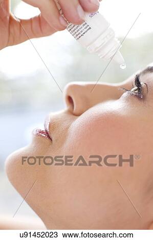 Stock Image - Woman using eye drops. Fotosearch