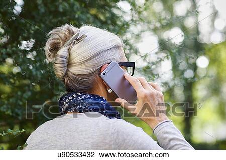 Woman using smartphone outdoors View Large Photo Image Stock Image - Woman using smartphone outdoors. Fotosearch