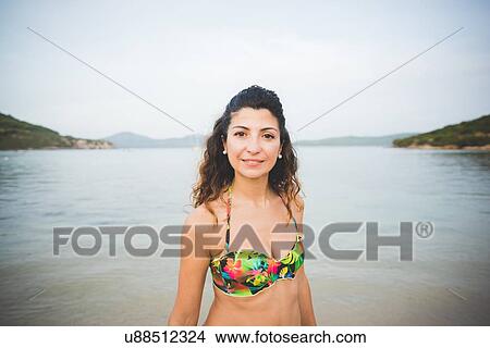 Woman wearing bikini top, sea in background View Large Photo Image Picture - Woman wearing bikini top, sea in background. Fotosearch