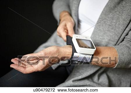 Stock Image - Woman wearing pulse watch. Fotosearch
