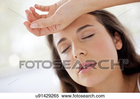 Stock Photography - Woman with hand on forehead. Fotosearch