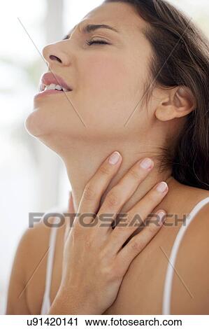 Stock Image - Woman with hand on throat in pain. Fotosearch