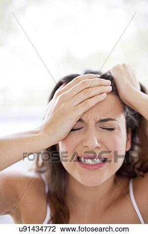 Stock Image - Woman with hands in hair. Fotosearch