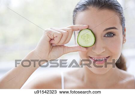Woman with slice of cucumber View Large Photo Image Stock Image - Woman with slice of cucumber. Fotosearch