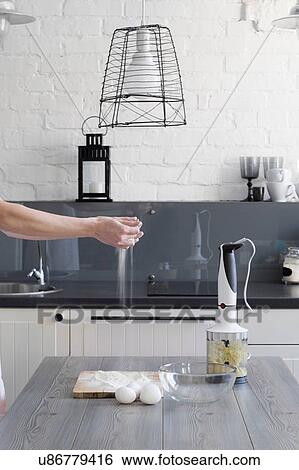 Womans hands sprinkling flour over cutting board at kitchen table View Large Photo Image Stock Photograph - Womans hands sprinkling flour over cutting board at kitchen table. Fotosearch