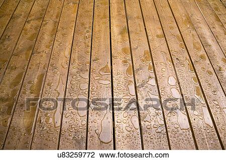 Stock Image - Wooden patio deck surface with water repellant stain applied. Fotosearch