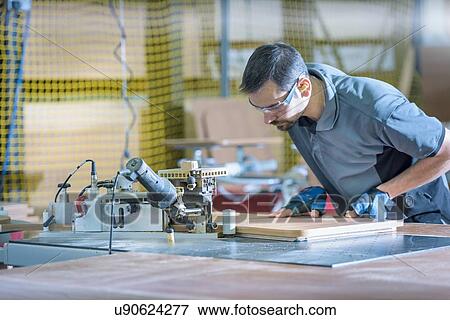 Worker cutting timber in motorhome factory View Large Photo Image Stock Photo - Worker cutting timber in motorhome factory. Fotosearch