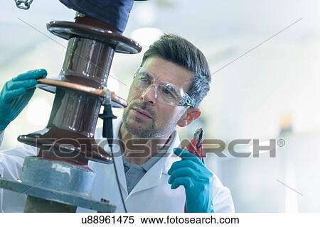 Stock Photography - Worker inspecting electrical insulator from power distribution network. Fotosearch