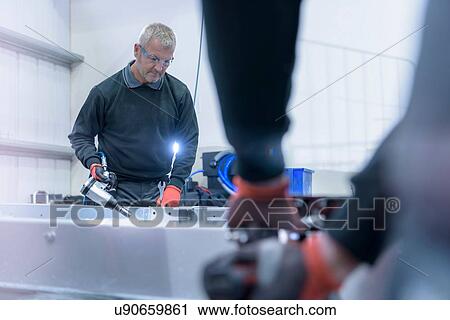 Workers fitting chassis on motorhome production line View Large Photo Image Stock Image - Workers fitting chassis on motorhome production line. Fotosearch