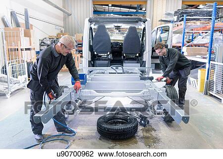 Workers fitting chassis on motorhome production line View Large Photo Image Stock Image - Workers fitting chassis on motorhome production line. Fotosearch